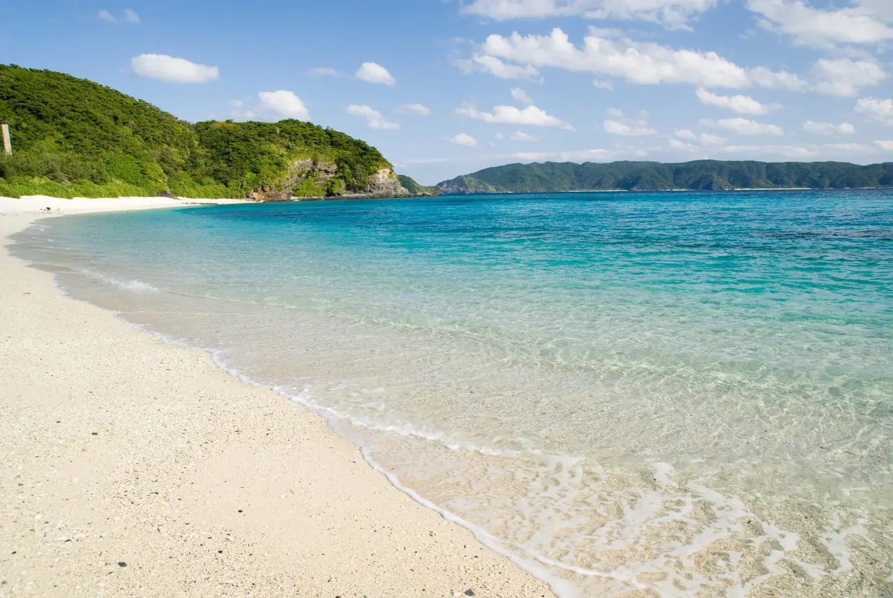 Clear turquoise water meeting the white sand of Furuzamami Beach, Okinawa